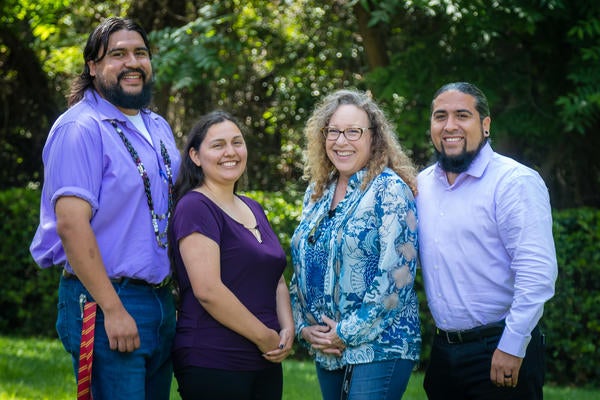 Four NASP staff members smile for the camera on the UC Riverside campus