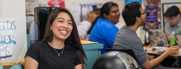 A student smiles as she hangs out with friends in the NASP office