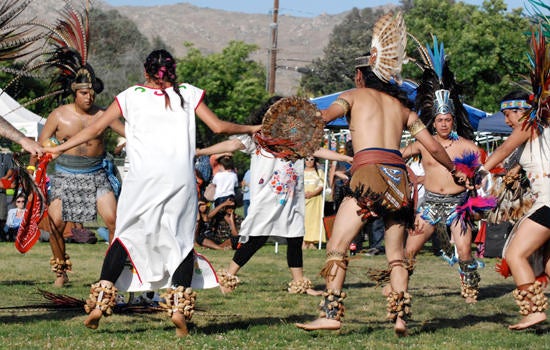 Performers hold hands in a circle during the NASP Pow Wow at UC Riverside