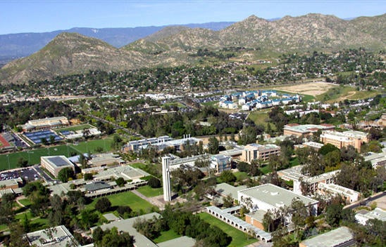 A bird's eye view of the UC Riverside campus, surrounding residential community, and mountain range